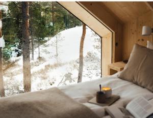 InkooHilltop Forest的卧室配有床,大窗户外有雪