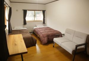 ShimotakaiActive House Ryuo - Vacation STAY 04019v的一间卧室配有一张床、一张沙发和一把椅子