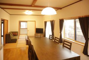 ShimotakaiActive House Ryuo - Vacation STAY 04019v的客厅配有大木桌和椅子