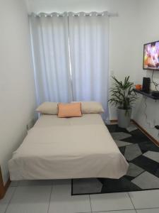 布卢梅瑙Apartamento ao lado da Vila Germânica的一间卧室配有一张带白色床单的大床