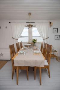 埃克奈斯Kesämökki meren rannalla, 5 km Tammisaaren keskustaan的餐桌、白色桌布和椅子