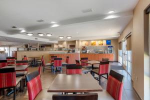 弗利弗利北部湾岸康福特套房酒店的餐厅设有木桌和红色椅子