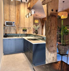 RossumLandgoed Lodges Scholten Linde的一间设有蓝色橱柜和蓝色岛屿的厨房