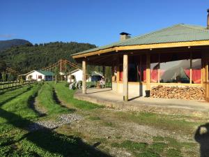 La JuntaLos Coihues Patagonia Lodge的一座农场,有一座建筑和一个草地