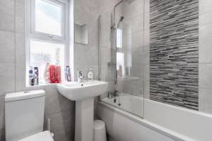利物浦Denebank Lodge - Anfield Apartments的浴室配有盥洗盆、卫生间和浴缸。