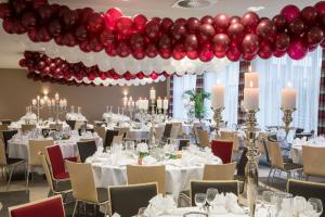 诺伊斯Holiday Inn Düsseldorf-Neuss, an IHG Hotel的宴会厅配有白色桌子和红色气球