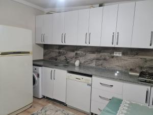 费特希耶Bahçeli büyük köy evi的厨房配有白色橱柜和白色冰箱。