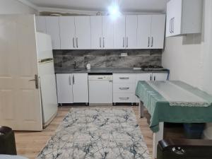 费特希耶Bahçeli büyük köy evi的厨房配有白色橱柜、桌子和冰箱。