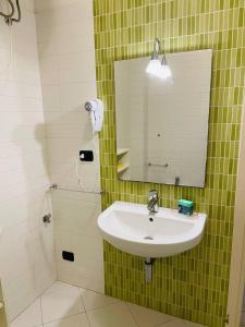 蒂勒尼亚Regina Del Mare Holiday Apartments的一间带水槽和镜子的浴室