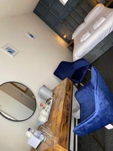 滨海纽比金老船酒店的一间设有两张蓝色椅子和镜子的房间