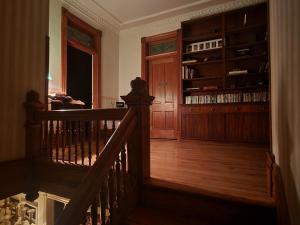 普韦布洛Downen House Bed & Breakfast的楼梯通往带书架的房间