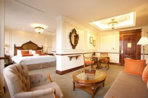 基多广场大酒店的酒店客房配有床、沙发和桌子。