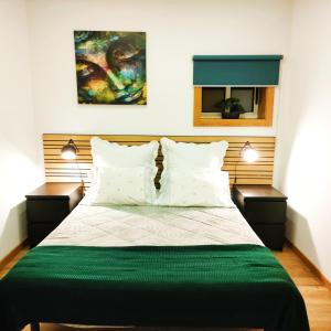 加亚新城Herama Garden Guesthouse的一间卧室配有一张带2个床头柜的大床