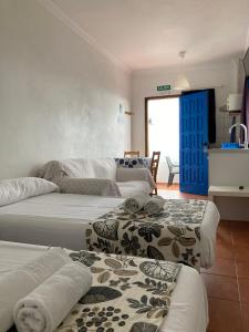拉卡莱塔Apartamentos y Habitaciones Villa Marina的一间设有四张床的客房,备有毛巾