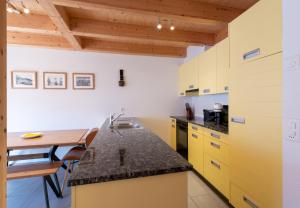 翁根Racers Retreat 10的厨房配有黄色橱柜和木桌