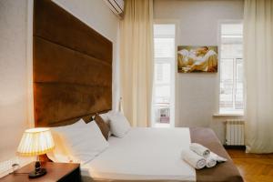 巴库City Inn Nizami Boutique Hotel的卧室配有一张白色大床和一幅画