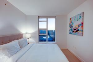 温哥华Downtown Properties的白色的卧室设有一张大床和一个窗户