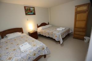 卡哈马卡Witobi Hostal的一间酒店客房,设有两张床和一扇门