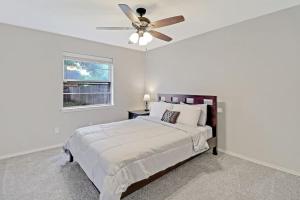 Saginawcozy house Saginaw TX 3BR 2BA Sleeps 10 just 12 minutes downtown fort worth的白色卧室配有床和吊扇