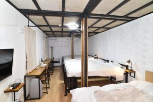 小樽Motel inn Minami Otaru / Vacation STAY 50438的带三张床和桌椅的房间
