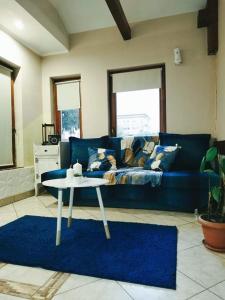 米什科尔茨Rákóczi Guesthouse Miskolc的客厅配有蓝色的沙发和桌子