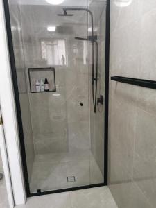布里斯班Eight Mile Plains House的浴室里设有玻璃门淋浴