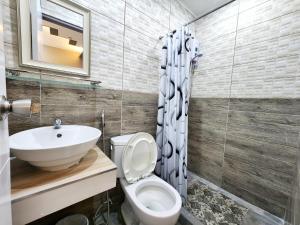 奥隆阿波New Kong's Hotel的一间带卫生间和水槽的浴室