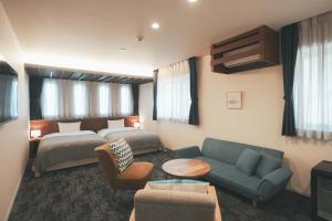 广岛LAZULI Hiroshima Hotel and Lounge的酒店客房,配有床和沙发