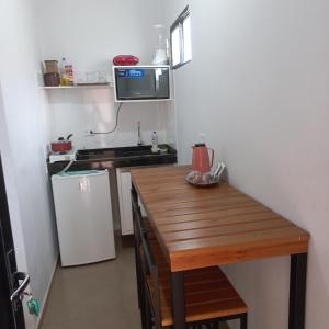 卡罗莱纳kitnet completa no Centro的一间带木桌和微波炉的小厨房