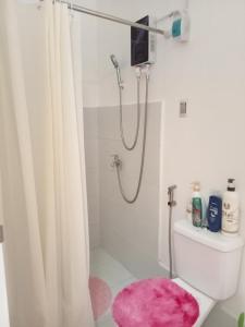 利帕Phirst Park Homes Townhouse的带淋浴的浴室(铺有粉红色地毯)