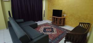 巴特沃思Al Irfan Homestay Tmn SgDua Utama的客厅配有蓝色的沙发和电视