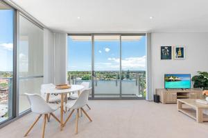 悉尼Skyview Comfy Apt in Centre of Burwood的客厅配有桌椅和窗户。
