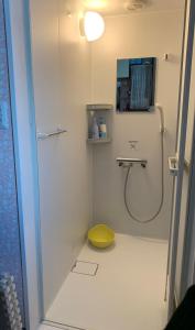 札幌霍塔住宿加早餐旅馆的带淋浴和黄色凳子的浴室