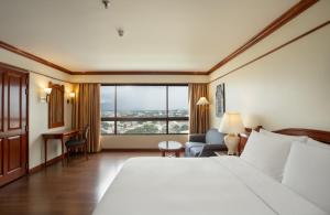 清迈Centara Riverside Hotel Chiang Mai的酒店客房设有一张床和一个大窗户
