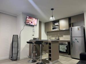 圣地亚哥Depto nuevo en Santiago的带冰箱的厨房和墙上的电视
