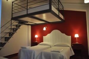 卡尔伦蒂尼里卡蒂亚农场酒店的一间带两张床的卧室和螺旋楼梯