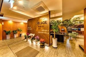 济州市The Jade Hotel的大厅里有盆栽植物和标志