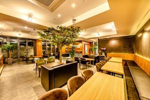 济州市The Jade Hotel的餐厅设有木桌和椅子,种有植物