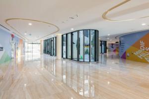 迪拜Brand New Studio Near Dubai Airport的大型大堂设有大型走廊,配有玻璃窗
