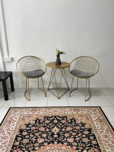 斯里伊斯兰德Camelia Homestay的地毯间配有两把椅子和一张桌子