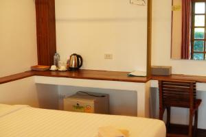 尖竹汶Annowa Resort - Chanthaburi的一间卧室配有一张桌子、一张床和一把椅子