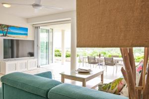 努萨角Crest Premium View Apartment 19的客厅配有蓝色的沙发和桌子