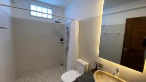珀尼达岛Khamara Nusa Penida的一间带水槽、卫生间和镜子的浴室