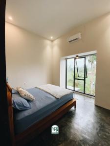 庞岸达兰Kmanda House的一间卧室设有一张床和一个大窗户