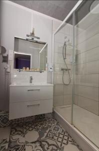 蒙马罗Logis Hôtel Le Bocage的带淋浴、盥洗盆和镜子的浴室
