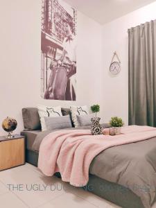 甘榜龙溪THE UGLY DUCKLING HOMESTAY的一间卧室配有一张带粉色毯子的大床