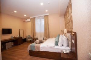 巴库Auroom Hotel的配有一张床和一张书桌的酒店客房