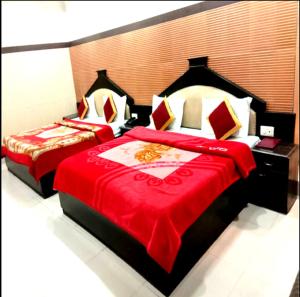 贾姆穆Hotel Surya Excellency By WB Inn的卧室内的两张床和红色毯子