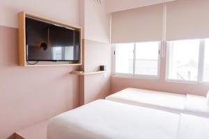 三宝垄Kotta Hotel Semarang的一间卧室配有一张床和一台平面电视