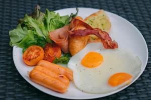彭世洛升逸精品酒店的包括鸡蛋培根和蔬菜的早餐食品